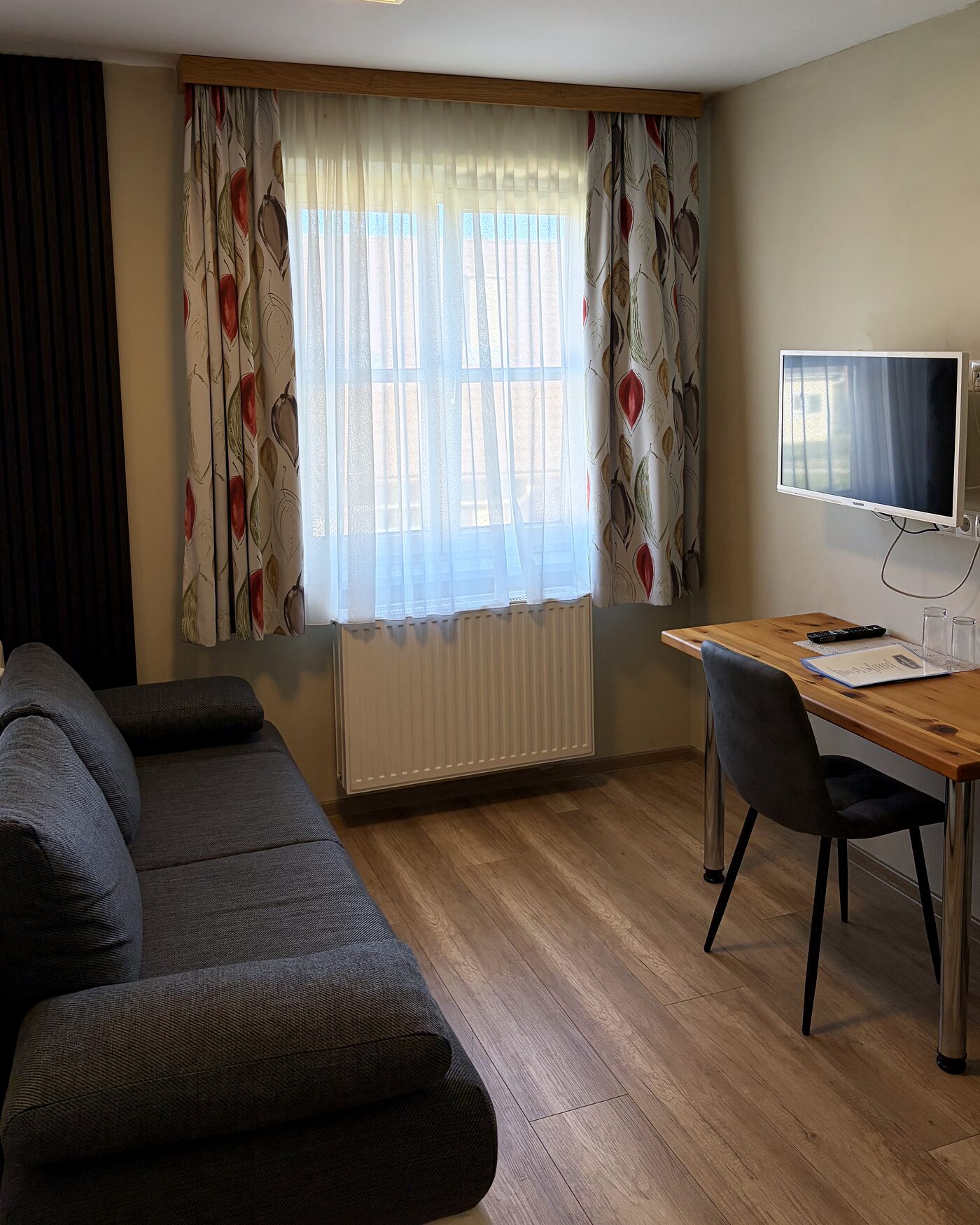 Sitzecke mit Schlafsofa, Schreibtisch und Fernseher